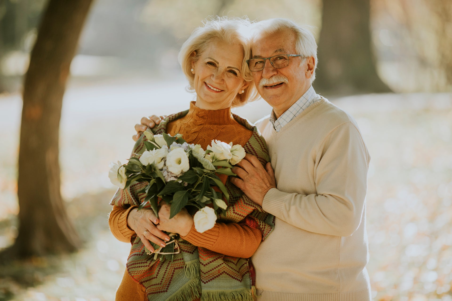 Ein Senior Paar mit Blumen lachen