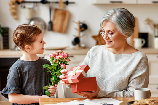 Glückliches-Kind-Enkelin gratuliert ihrer Oma gibt ihr Blumen Geschenk