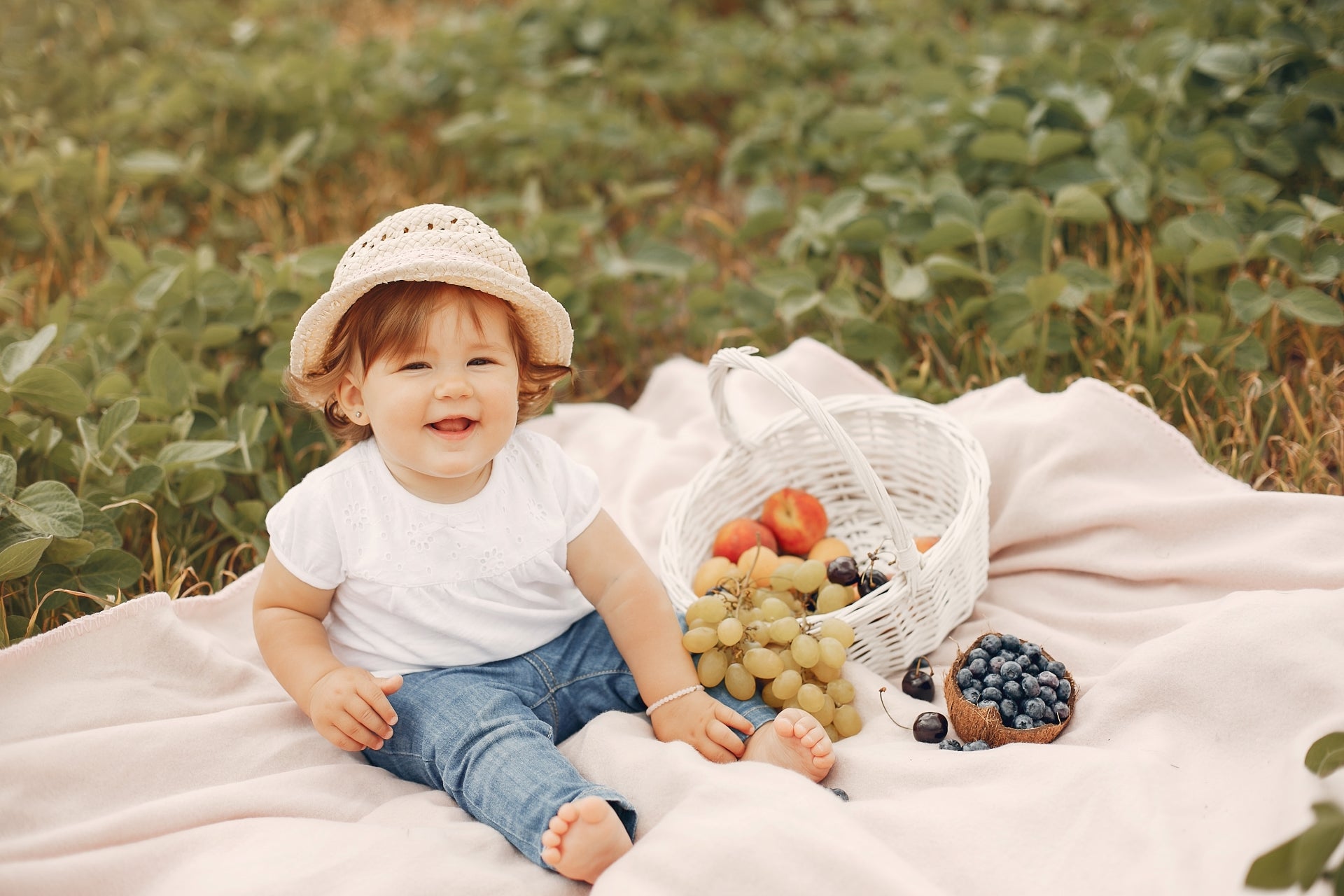 Süßes Baby sitzt auf der Decke im Park