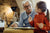 Älterer Großvater redet seine Enkelin beim zusammen malen Zuhause